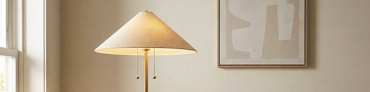 Brass Floor Lamp with wide natural linen shade in a neutral living room with wall art