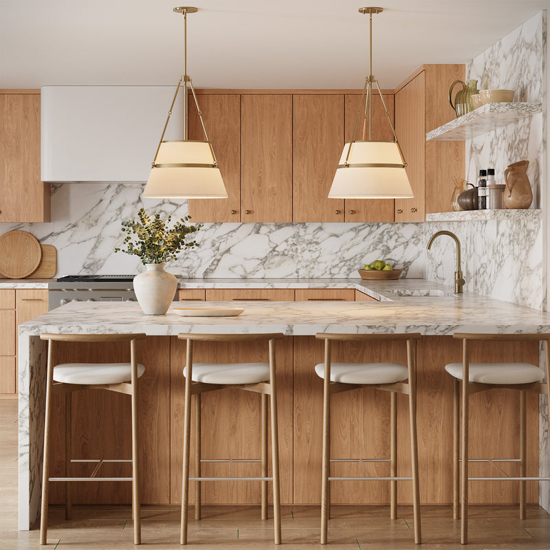 Two Julien Pendant Lights hung in a kitchen with marble slab waterfall counters and oak cabinets