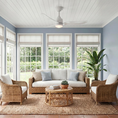 A coastal sunroom featuring the white powder-coated Kent LED Outdoor Ceiling Fan with Light 42", White on a shiplap ceiling above wicker furniture and blue walls.