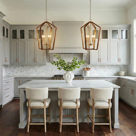 A transitional kitchen featuring two Talin Lantern Pendant 20-inch, Chestnut and Matte Brass fixtures hanging over a marble island with gray cabinets and a geometric tile backsplash.