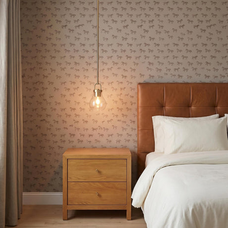 A transitional bedroom featuring the Naya Small Pendant 6" in satin brass and clear glass hanging over a light wood nightstand beside a cognac leather headboard.