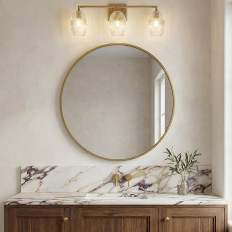 Fiora 3 Light Vanity 24", Modern Brass scalloped globe vanity in a Transitional Bathroom with a gold mirror and marble countertop.