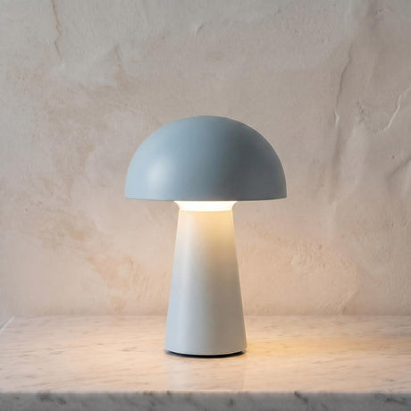 A modern living room with a baby blue matte finish table lamp on a white marble countertop set against a neutral textured plaster wall backdrop.