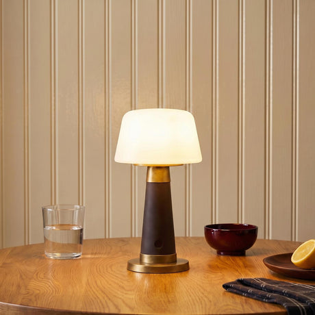 A traditional dining room featuring the Galina Rechargeable Table Lamp 11", Espresso Vegan Leather and Vintage Brass on a wooden table against a cream beadboard wall.