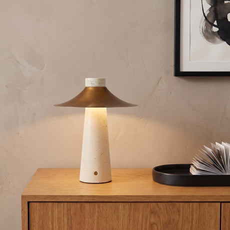 A contemporary living room featuring the Akari Rechargeable Table Lamp 12", Travertine and Vintage Brass on a light wood sideboard beside a black decorative tray.