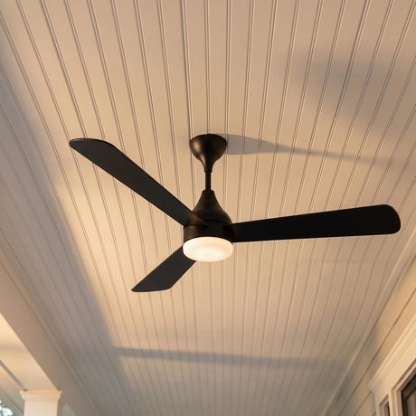 A modern farmhouse porch with a Serin LED Ceiling Fan 60" in matte black featuring a glowing light kit mounted to a white beadboard ceiling.