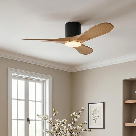A modern living room featuring the Eider LED Ceiling Fan with natural oak blades and a matte black motor installed at the ceiling center above cream walls.