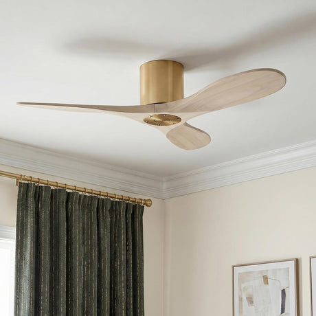 A modern living room featuring the Eider Ceiling Fan 44", Whitewash Oak and Modern Brass, installed on a standard ceiling above dark green curtains and framed art.