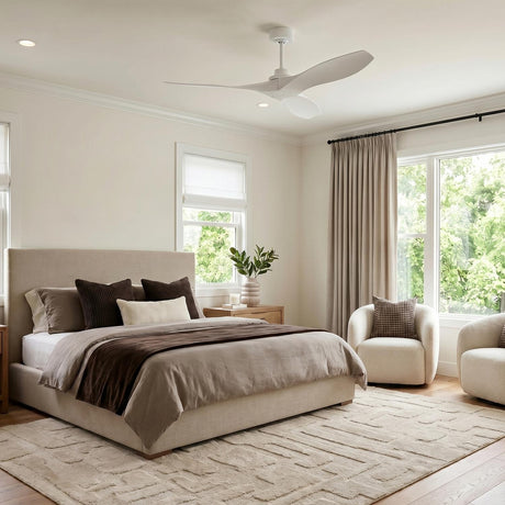 A modern home exterior with a matte white Heron Outdoor Smart Ceiling Fan on a white porch ceiling with siding and large windows overlooking lush green landscaping.