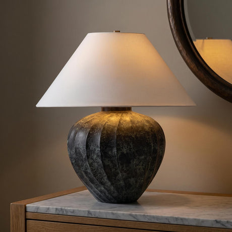 A transitional foyer featuring the Calloway Table Lamp 23", Black Patina Metal with a white linen shade on a marble-topped wood console near a hammered mirror.
