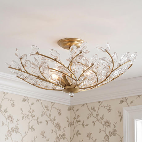 A traditional bedroom featuring the Esme Semi-Flush 22 inch soft brass and clear glass leaf fixture along the ceiling above floral wallpaper and white crown molding.