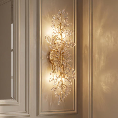 A transitional hallway with an Esme Wall Sconce 24", Soft Brass and Clear Glass featuring leaf accents mounted on a beige paneled wall.
